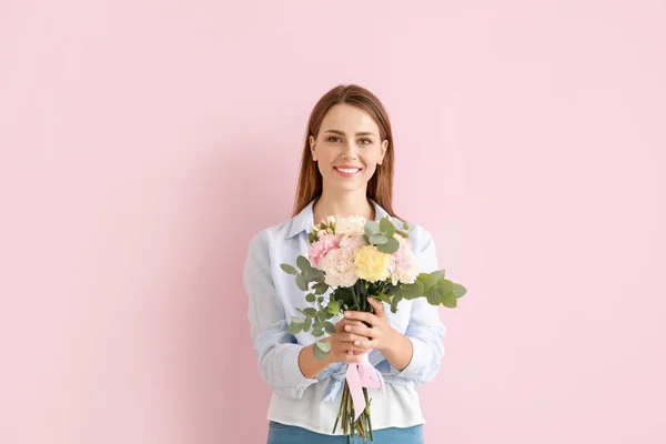 Vacker ung kvinna med bukett nejlika blommor på färg bakgrund — Stockfoto