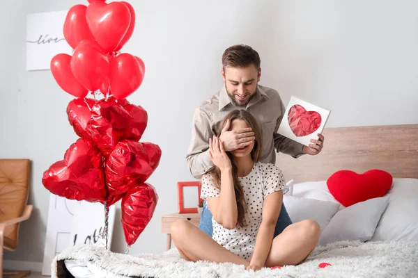 Jovem casal feliz celebrando o Dia dos Namorados em casa — Fotografia de Stock