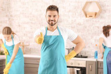 Male janitor showing thumb-up gesture in kitchen clipart