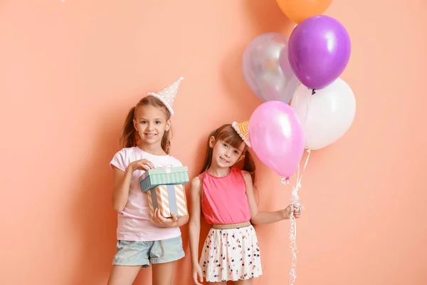 Little girls with Birthday air balloons and gifts on color background — Stock Photo, Image