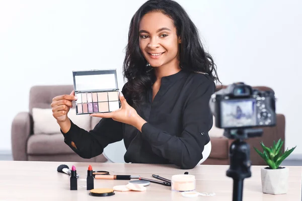 Young African-American beauty blogger recording video at home