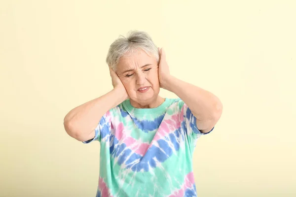 Senior woman with hearing problem on light background — Stock Photo, Image