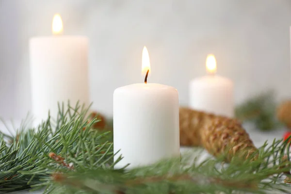 Glowing candle with Christmas decor on white background — ストック写真