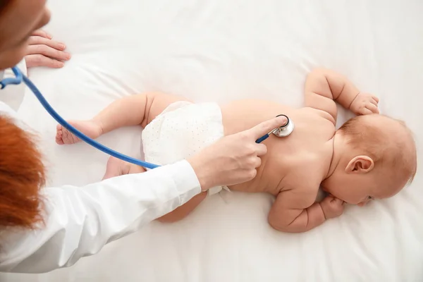 Børnelæge undersøger sød baby i klinikken - Stock-foto