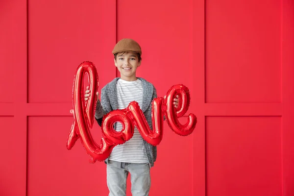 사랑이라는 단어를 배경으로 풍선을 타고 있는 귀엽고 귀여운 소년 이 있습니다. 발렌티누스 축일 기념행사 — 스톡 사진