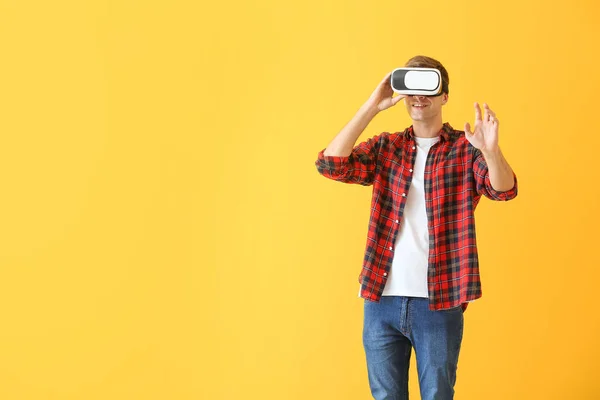 Giovane uomo con occhiali di realtà virtuale su sfondo a colori — Foto Stock