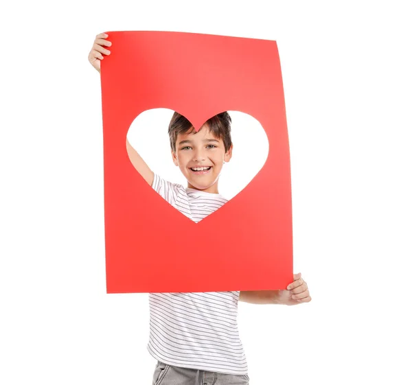 Söt liten pojke som håller pappersark med hål i form av hjärta på vit bakgrund. Alla hjärtans dag firande — Stockfoto