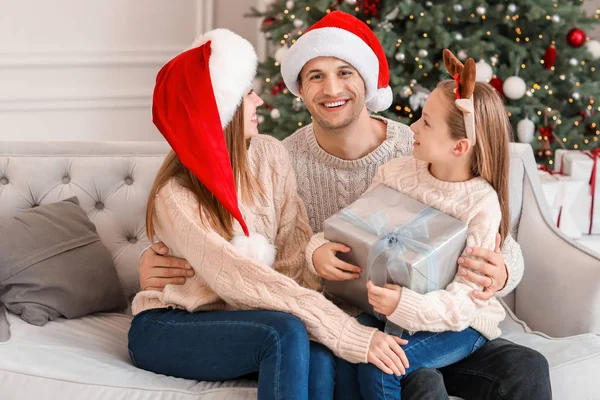 Mutlu, genç bir aile Noel hediyesiyle evde — Stok fotoğraf