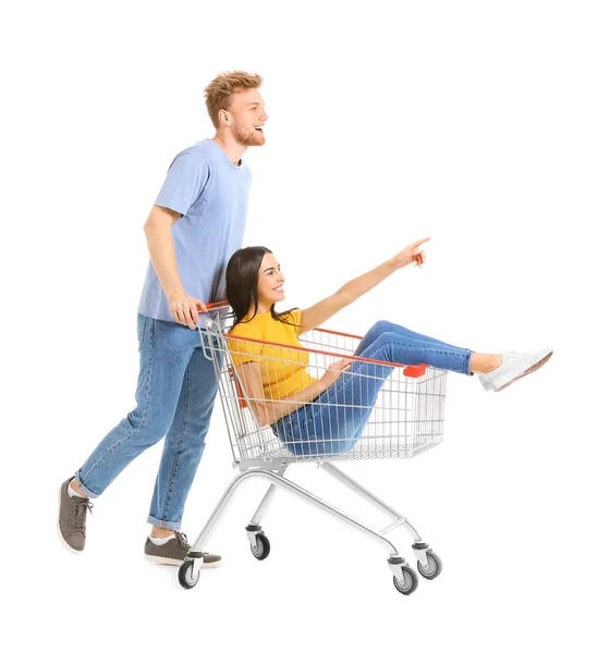 Casal jovem com carrinho de compras no fundo branco — Fotografia de Stock