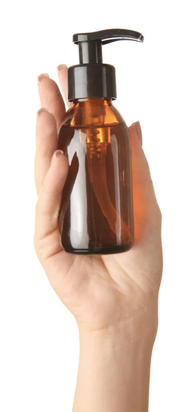 Mão feminina com produto cosmético em garrafa sobre fundo branco — Fotografia de Stock