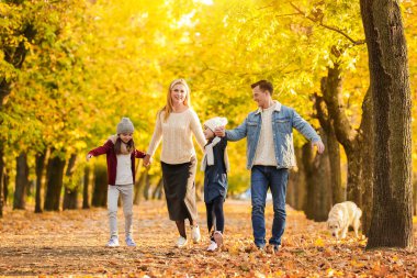 mutlu bir aile sonbahar parkta yürüyüş