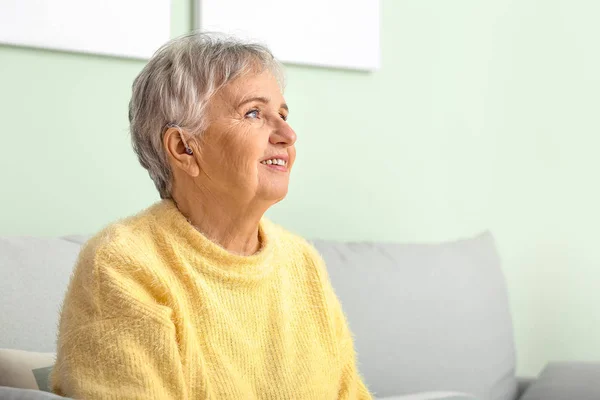 Senior woman with hearing aid at home — Stock Photo, Image