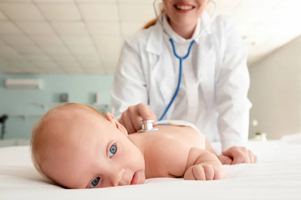 Kinderarts onderzoekt schattige baby in kliniek — Stockfoto