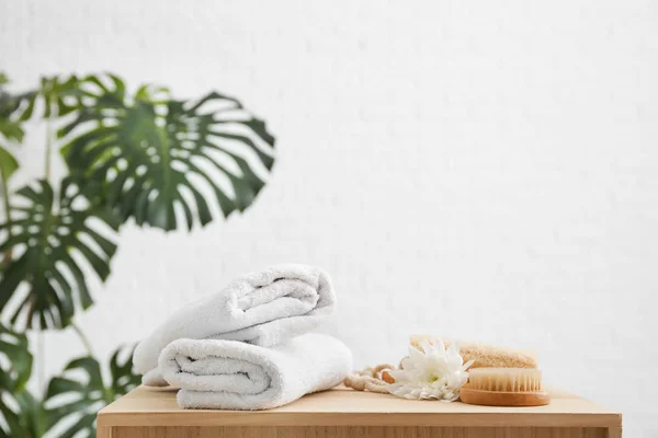 Toalhas limpas, escova e loofah na mesa — Fotografia de Stock