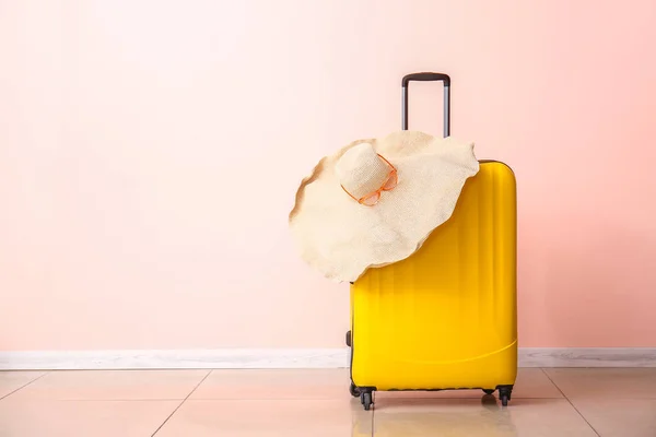 Koffer en strand hoed in de buurt van kleur muur. Reisconcept — Stockfoto
