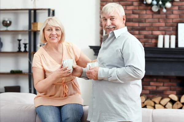 Feliz pareja madura bebiendo chocolate caliente en casa —  Fotos de Stock