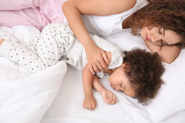 Niña afroamericana con madre durmiendo en la cama — Foto de Stock