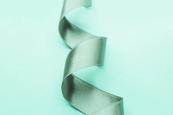 Beautiful turquoise ribbon on color background — Stock Photo, Image