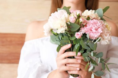 Ahşap arka planda karanfil çiçekleri olan güzel bir kadın, yakın plan.