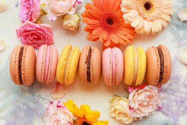 Beyaz arka planda çiçekli farklı lezzetli kurabiyeler.