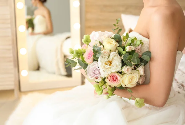 Beautiful young bride with bouquet of flowers at home — Stock Photo, Image