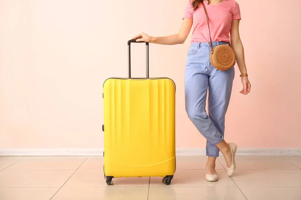 Žena s kufrem u barevné zdi. Cestovní koncept — Stock fotografie