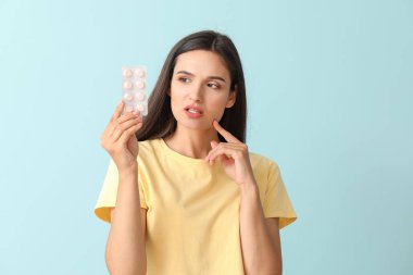 Renkli arka planda hapları olan genç bir kadın