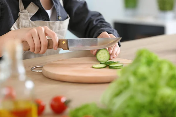 Kvinna som förbereder läckra grönsakssallad i köket — Stockfoto