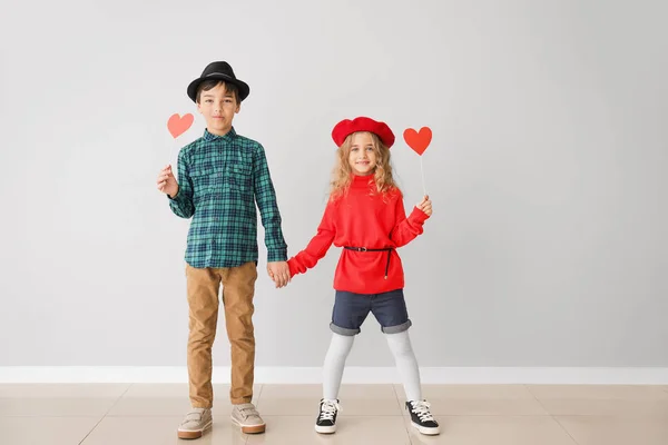 Piccoli bambini carini con cuori rossi su sfondo grigio. Festa di San Valentino — Foto Stock