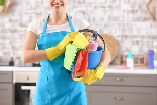 Female janitor with cleaning supplies in kitchen — Stock Photo, Image