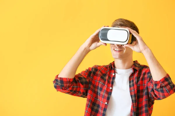 Giovane uomo con occhiali di realtà virtuale su sfondo a colori — Foto Stock
