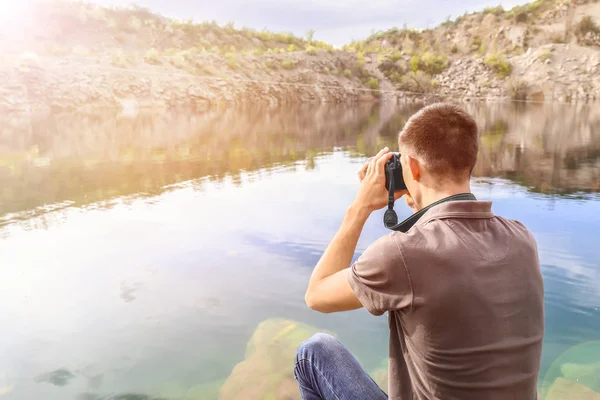 Turista masculino tomando fotos de lago de montaña — Foto de Stock