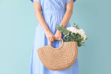 Renkli arka planda bir demet karanfil çiçeğiyle güzel bir genç kadın.