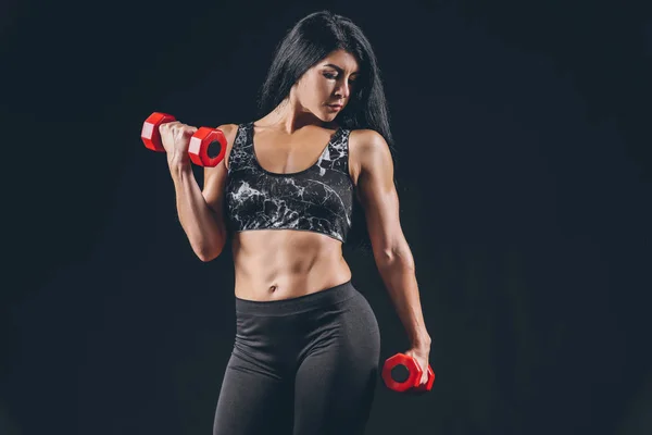 Sporty muscular woman with dumbbells on dark background — Stock Photo, Image