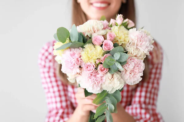 Beautiful young woman with bouquet of carnation flowers on light background, closeup — Stock Photo, Image