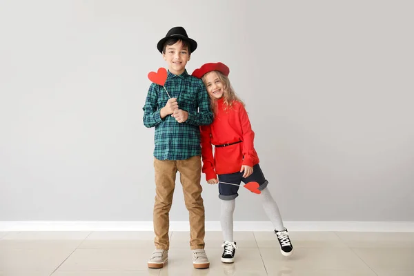 Lindos niños pequeños con corazones rojos sobre fondo gris. Celebración de San Valentín — Foto de Stock