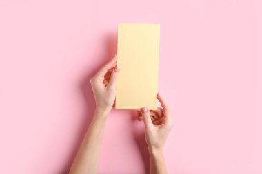 Renk arkaplanı üzerinde boş menüye sahip kadın elleri