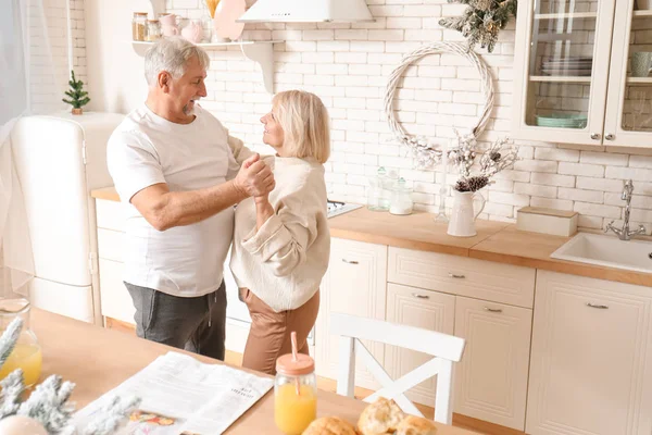 Happy mature couple dancing in kitchen — Stock Photo, Image