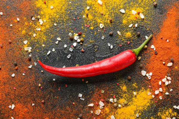 Chili pepper and different spices on dark background — Stock Photo, Image