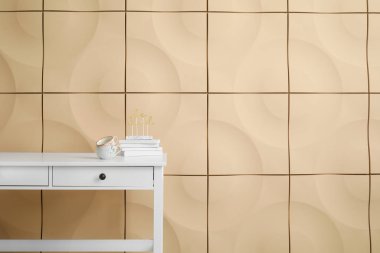 Renk duvarının yanında fincanları ve kitapları olan beyaz masa