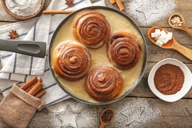Lezzetli tarçınlı tava ve ahşap masada krema.