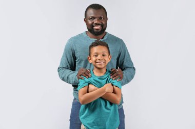 Hafif arka planda küçük oğlu olan Afro-Amerikan bir adamın portresi.
