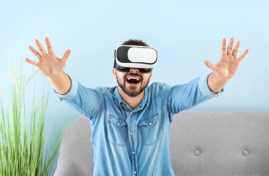 Evde sanal gerçeklik gözlüklü genç bir adam