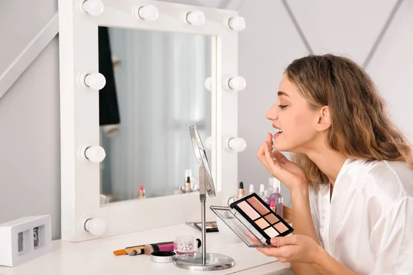 Morning of beautiful young woman applying makeup in bedroom — Stock Photo, Image