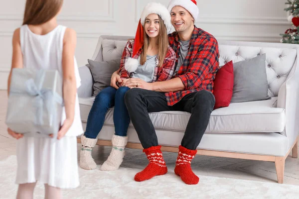 Menina dando presente de Natal para seus pais em casa — Fotografia de Stock