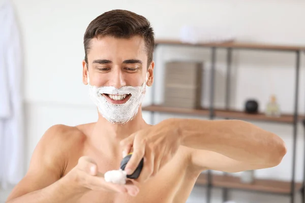 Schöner junger Mann rasiert sich zu Hause — Stockfoto