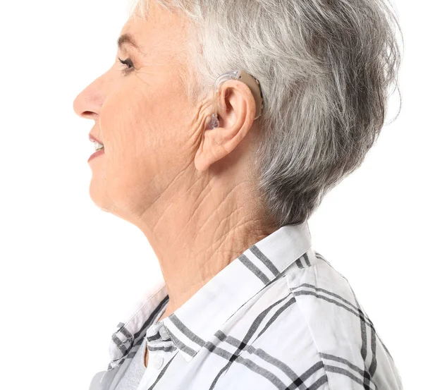 Senior woman with hearing aid on white background — Stock Photo, Image