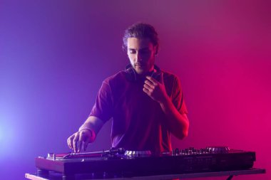 Gece kulübünde erkek DJ çalıyor.