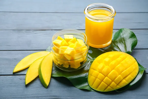 Samenstelling met zoete rijpe mango 's en sap op houten tafel — Stockfoto