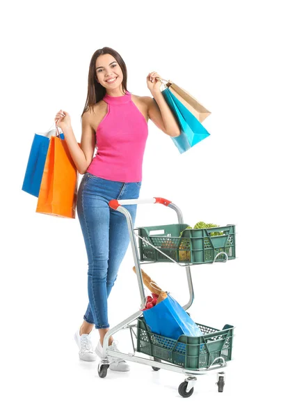 Mujer joven con carrito de compras sobre fondo blanco — Foto de Stock